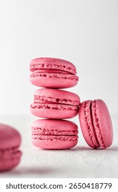 Stack of pink Macarons on white textured background isolated. Vertical