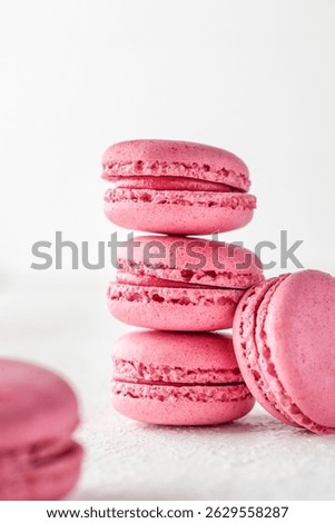 Stack of pink Macarons on white textured background isolated. Vertical