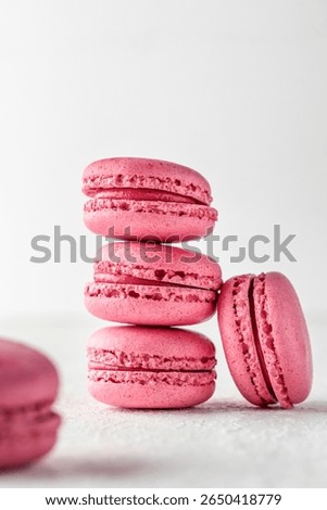 Stack of pink Macarons on white textured background isolated. Vertical