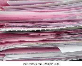 Stack of Pink and White Paper Documents in Office Showing Layers of Reports, Forms, and Administrative Files Close Up