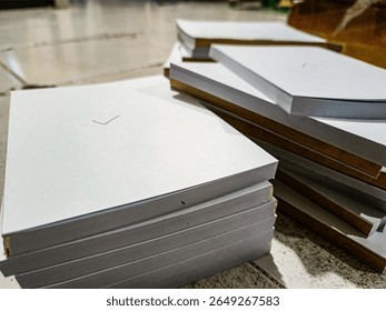 A stack of plain white square book covers.

