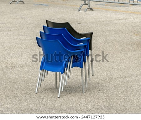 Stack of plastic chairs outside in a park