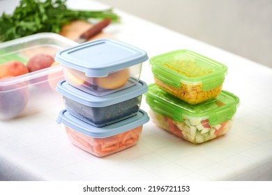 Stack Of Plastic Containers With Raw Cut Vegetables For Freezing On Kitchen Table. Storage For Winter Storage In Plastic Containers