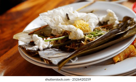 A stack of plates and leftover food has accumulated, creating a noticeable pile of waste.  - Powered by Shutterstock