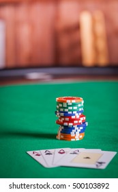 Stack of poker chips by playing cards 
