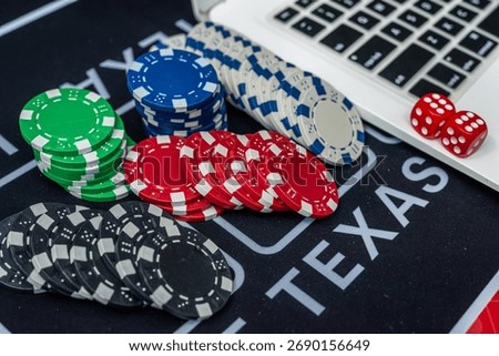 Stack of poker chips and dice near laptop keyboard representing online gambling, casino games and betting