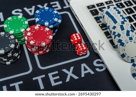 Stack of poker chips and dice near laptop keyboard representing online gambling, casino games and betting