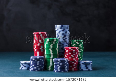 stack of poker chips on a blue table on a black background