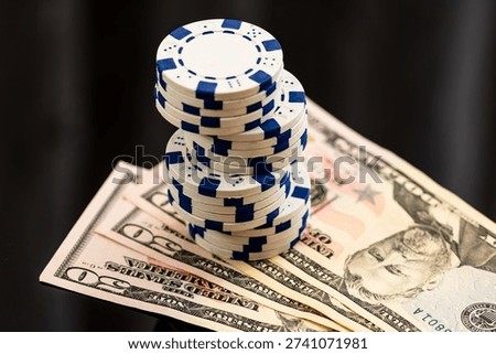 Stack of poker chips over american dollar bills and playing cards representing casino gambling and risk