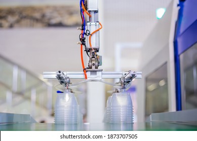 Stack Of Polypropylene Food Containers On Conveyor Belt Of Automatic Plastic Injection Molding Machine With Robotic Arm At Exhibition, Trade Show. Manufacturing, Industry, Automated Technology Concept