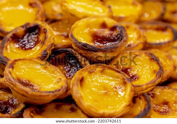 Stack of Portuguese egg tart (Pasteis de Nata)\
display in front of shop, A delicious local favourite dessert with\
pastry shell, Sweet tarts with an aromatic custard that gets baked\
and scorched on top