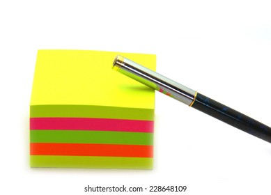 Stack Of Post Its And A Pen On A White Background.