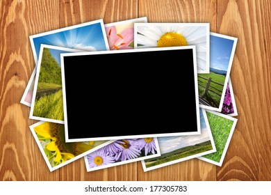 Stack of printed pictures collage on wooden table with copy space for your photo