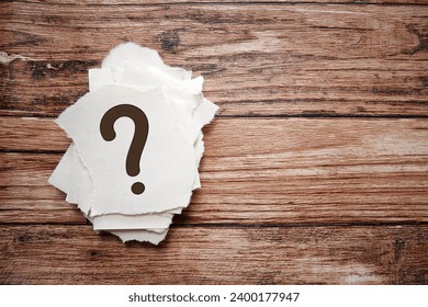 Stack of question marks on paper, top view on wooden table. Question, confusion and solution concept.  - Powered by Shutterstock