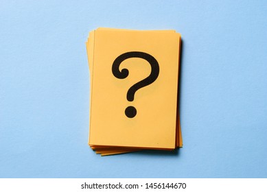 Stack of question marks on yellow cards arranged to the side on blue background with copy space