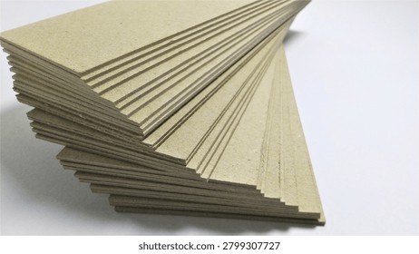 A  stack of rectangular yellow boards strips or cards arranged on a plain white surface.
