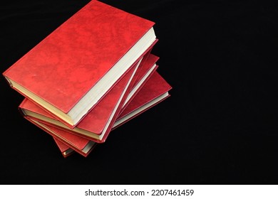 a stack of red books on a black background