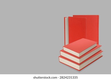 Stack of red books on a gray backdrop for study purposes