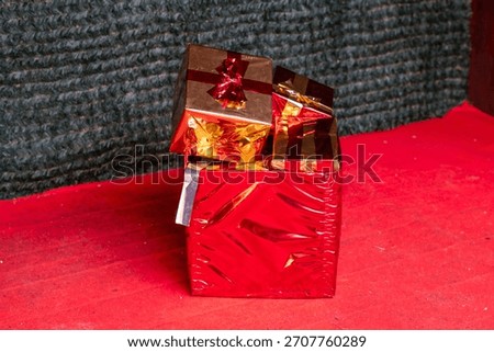 Stack of red and gold gift boxes placed on a red floor creates a striking festive Christmas market decoration atmosphere