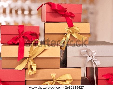 A stack of red, gold, and silver gift boxes with ribbons, a festive display for the holidays, concept of christmas, new year, celebration. High quality photo