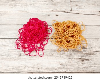 Stack of Red rubber band bracelets on wooden background. 