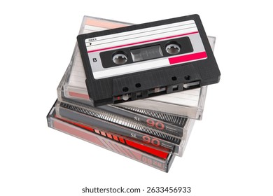 Stack of retro audio cassettes with one on top, angled and uncovered, on white background.