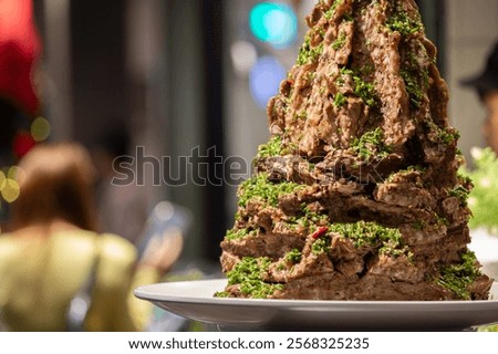A stack of ribs presented at a counter at Jodd Fairs Night Market in Bangkok, Thailand.