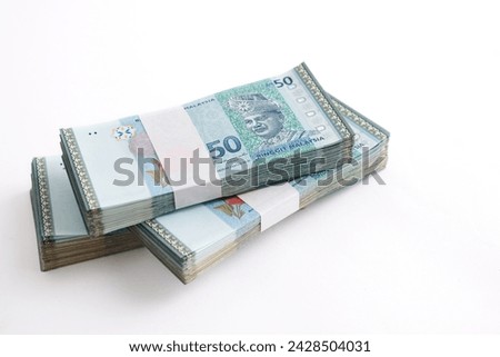 Stack of Ringgit Malaysia bank note on white background. Malaysia Currency Ringgit RM50. Selective focus.