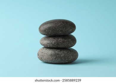 Stack of rocks on light blue background. Harmony and life balance
