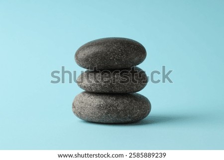 Stack of rocks on light blue background. Harmony and life balance