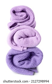 Stack of rolled lilac sweaters on white background