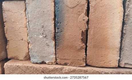 Stack of rough-hewn terracotta bricks with varied textures and earthy tones.