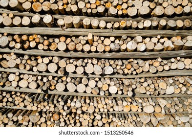 Stack of round cut logs,  firewood devided by horizontal planks.