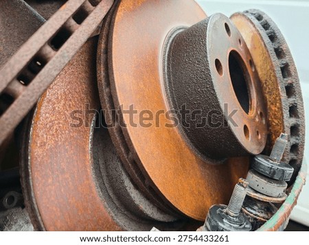 stack of rusty brake discs and car parts, closeup of used automotive brake rotors with corrosion texture, mechanical spare parts in repair workshop