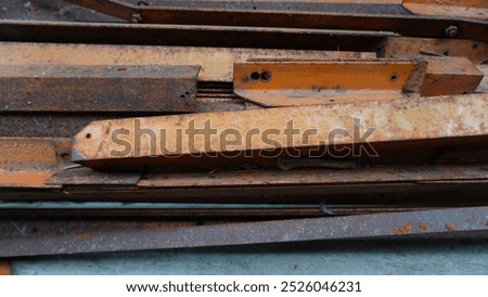 Stack of Rusty Brown-Painted Metal Beams with Holes