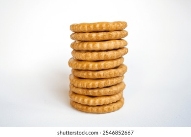 Stack of sandwich biscuits filled with peanut butter flavored cream on a white background