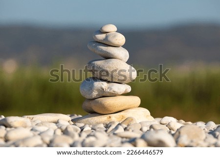 Stack of several rounded stones, on a beach in the morning, in a natural setting, arranged in balance and harmony