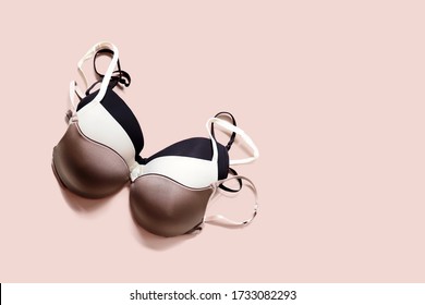 Stack of sexy bras on pink background, bra. Push up lingerie, classic colors: white, black, beige