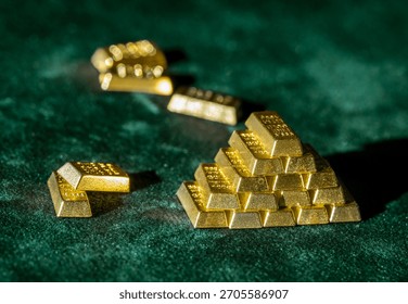 stack of shiny gold bars with scattered bitcoins on green fabric surface illustrating investment and trading concept