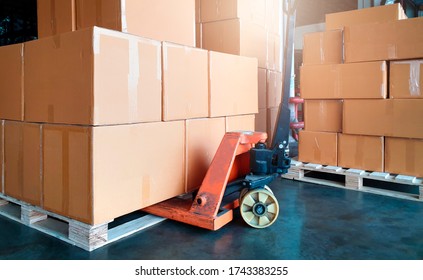 Stack of shipment boxes on pallet and hand pallet truck. Interior of warehouse storage, warehouse industry delivery shpping goods, logistics and transport.