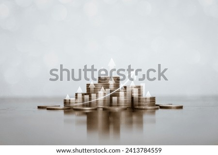 Stack of silver coins with an arrow pointing upwards with trading charts Concepts about finance, investing, interest, financial risk management, banking.