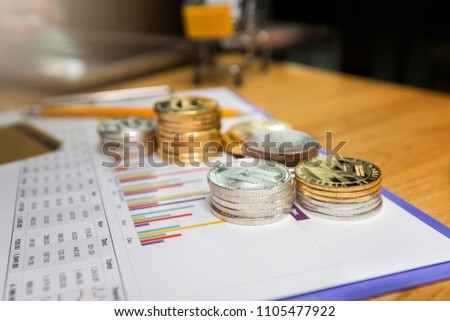 Stack of silver Dashcoins and golden Litecoins (Cryptocurrency) on paper graph. New Virtual money concept.