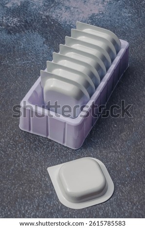Stack of single-use plastic containers for sauce or detergent. High quality photo