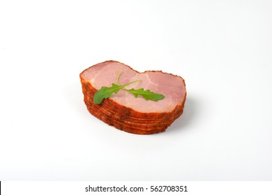 Stack Of Sliced Smoked Pork Meat With Arugula Leaves On White Background