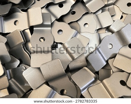 A stack of small metal plates with a hole in the center, designed for inserting and securing bolts