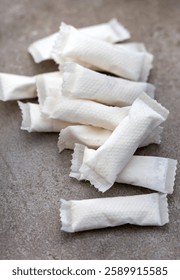 A stack of small nicotine pouched on a grey surface with selective focus