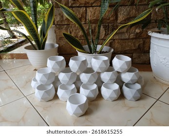 A stack of small white cement craft pots ready to be shipped