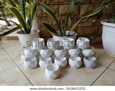 A stack of small white cement craft pots ready to be shipped