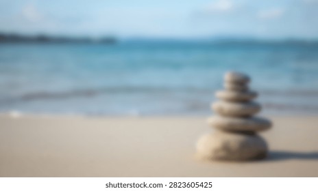 A stack of smooth stones balanced on a sandy beach with the ocean waves in the background, symbolizing peace and tranquility.