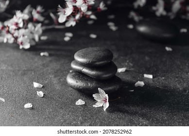 Stack Of Spa Stones And Flowers On Dark Background